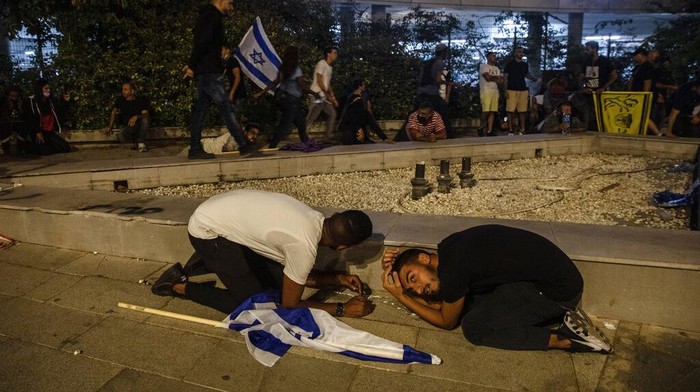 Balas Serangan, Hamas Tembakan Ratusan Roket ke Israel Jewish nationalist demonstrators take cover during a barrage of rockets fired from the Gaza Strip toward central Israel, in the Israeli town of Ramla, Tuesday, May 11, 2021. The protesters had gathered in an attempted show of strength in a predominantly Arab neighborhood. (AP Photo/Heidi Levine)