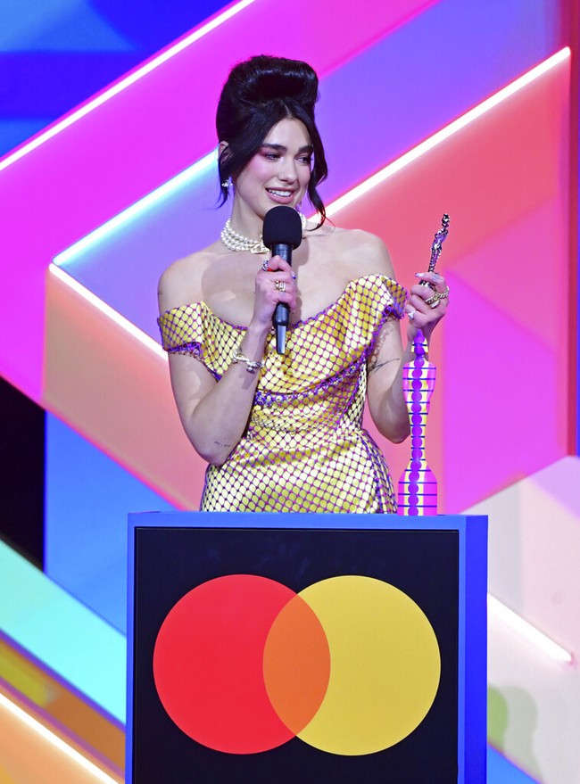 Amy Winehouse disebut menjadi inspirasi untuk gaya Dua Lipa ini. Di Brit Awards 2007, Amy mengenakan gaun kuning terang. Tak cuma gaya busana, hair-do Amy pun mengilhami Dua Lipa. (Foto: Ian West/PA via AP)