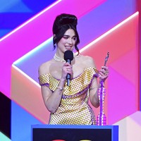Amy Winehouse disebut menjadi inspirasi untuk gaya Dua Lipa ini. Di Brit Awards 2007, Amy mengenakan gaun kuning terang. Tak cuma gaya busana, hair-do Amy pun mengilhami Dua Lipa. (Foto: Ian West/PA via AP)