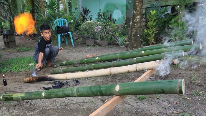 Sejumlah pemuda menyalakan beude trieng (meriam bambu) di Desa Alue Raya, Samatiga, Aceh Barat, Aceh, Rabu (12/5/2021). Memainkan meriam bambu telah menjadi tradisi yang dilakukan pemuda sebagai bentuk ekspresi kebahagiaan menyambut malam lebaran dan hari kemenangan setelah melaksanakan ibadah puasa. ANTARA FOTO/Syifa Yulinnas/foc.