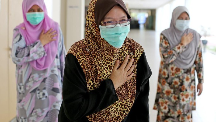 1225067542 A small group of female adults placed their right palm on left chest (Malaysian culture way greetings) as an alternative to handshakes during partial lockdown in Malaysia.