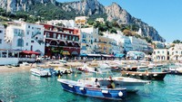 Di tebing-tebing Pulau Capri terhampar banyak vila hingga penginapan. Kamu pun juga bisa berbelanja di sejumlah toko yang ada di jalanan Capri. Setelah itu kamu bisa menghabiskan sore dengan jalan santai di pelabuhan sambil menunggu sunset. (Foto: Photo by Ellena McGuinness on Unsplash). 