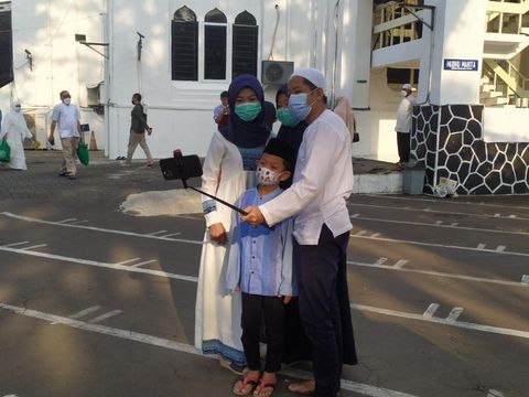 Jemaah bersama keluarganya mengabadikan momen Idul Fitiri 1442 H usai salat Id di Masjid Cut Meutia
