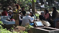 Warga datang silih berganti ke area pemakaman untuk berziarah dan mendoakan anggota keluarga mereka di momen Lebaran. 