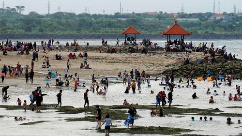 Wisatawan menikmati suasana liburan di Pantai Sanur, Denpasar, Bali, Kamis (13/5/2021). Obyek wisata yang dicanangkan sebagai kawasan zona hijau tersebut ramai dikunjungi wisatawan lokal pada liburan Idul Fitri 1442 Hijriah. ANTARA FOTO/Nyoman Hendra Wibowo/rwa.