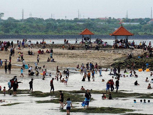Wisatawan menikmati suasana liburan di Pantai Sanur, Denpasar, Bali, Kamis (13/5/2021). Obyek wisata yang dicanangkan sebagai kawasan zona hijau tersebut ramai dikunjungi wisatawan lokal pada liburan Idul Fitri 1442 Hijriah. ANTARA FOTO/Nyoman Hendra Wibowo/rwa.