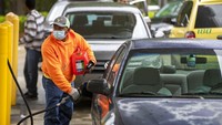 Seorang warga mengisi mobil dan wadah gas yang dibawanya dengan bahan bakar di pompa bensin yang berada di kawasan Raleigh, N.C, Rabu (12/5/2021) waktu setempat. Robert Willett/The News & Observer via AP. 