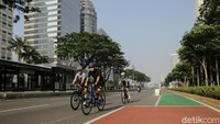 Sejumlah warga memanfaatkan sepinya jalanan di Ibu Kota untuk bersepeda di kawasan Jalan Sudirman, Jakarta.  