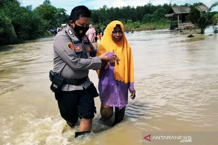 Anggota Polsek Satui, Polres Tanah Bumbu melakukan evakuasi terhadap warga terdampak banjir. (ANTARA/Firman/am)