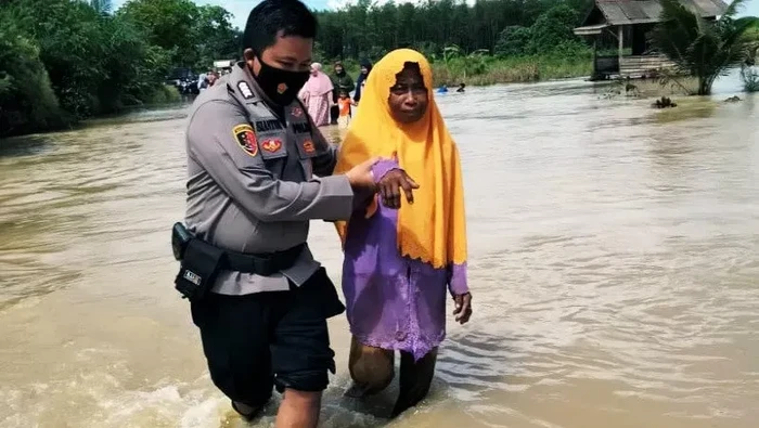 Anggota Polsek Satui, Polres Tanah Bumbu melakukan evakuasi terhadap warga terdampak banjir. (ANTARA/Firman/am)