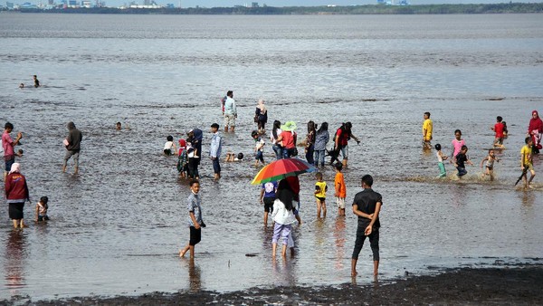 Sejumlah warga berwisata pada hari kedua Lebaran di Pantai Koneng Dumai, Riau, Jumat (14/5/2021). Obyek wisata pantai Dumai ramai dikunjungi warga pada hari kedua Lebaran yang datang dari luar daerah seperti Bengkalis, Rokan Hilir dan Pekanbaru meskipun ada larangan membuka tempat wisata oleh Polda Riau. ANTARA FOTO/Aswaddy Hamid. Sejumlah warga berwisata pada hari kedua Lebaran di Pantai Koneng Dumai, Riau, Jumat (14/5/2021). Obyek wisata pantai Dumai ramai dikunjungi warga pada hari kedua Lebaran yang datang dari luar daerah seperti Bengkalis, Rokan Hilir dan Pekanbaru meskipun ada larangan membuka tempat wisata oleh Polda Riau. ANTARA FOTO/Aswaddy Hamid.