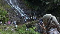 Seorang pengunjung berkomunikasi secara daring dengan keluarganya sambil menikmati wisata Curug Tujuh Cibolang, Kampung Sandingtaman, Kabupaten Ciamis, Jawa Barat, Jumat (14/5/2021). Wisatawan lokal memanfaatkan libur Lebaran berwisata bersama keluarga di kawasan wisata alam yang ditata oleh Perhutani Kesatuan Pemangkuan Hutan (KPH) Ciamis. ANTARA FOTO/Adeng Bustomi.