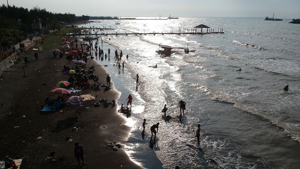 Foto udara pengunjung bermain air di pinggir pantai di Obyek Wisata Pantai Alam Indah, Tegal, Jawa Tengah, Jumat (14/5/2021). ANTARA FOTO/Oky Lukmansyah. Foto udara pengunjung bermain air di pinggir pantai di Obyek Wisata Pantai Alam Indah, Tegal, Jawa Tengah, Jumat (14/5/2021). ANTARA FOTO/Oky Lukmansyah.