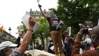Seorang pengunjuk rasa membagikan selebaran dalam aksi solidaritas dengan warga Palestina, di Paris, Rabu (12/5/2021) waktu setempat. AP Photo/Thibault Camus  