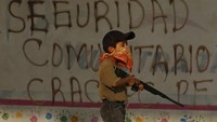 Seorang anak membawa replika senjata laras panjang di satu desa yang berada di kawasan Guerrero, Meksiko.  