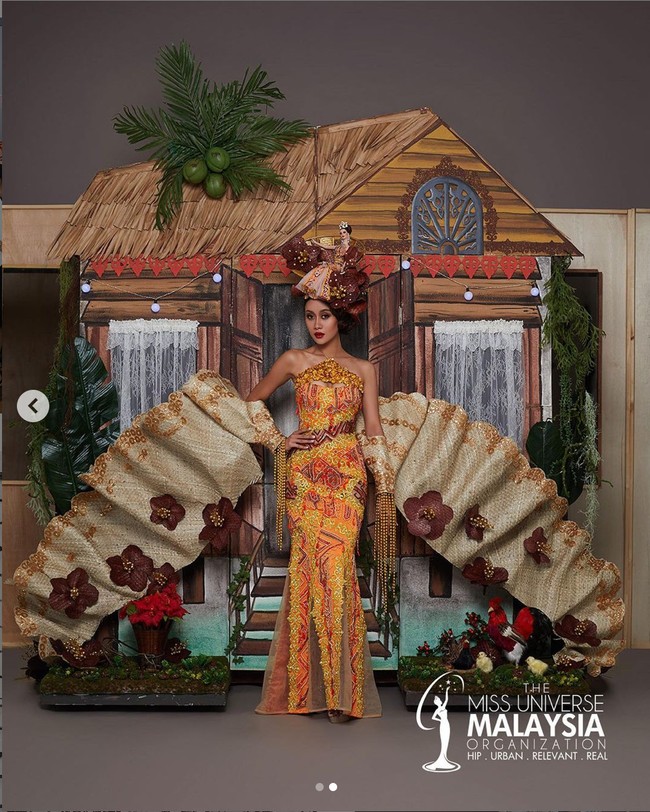 Tak kalah unik, kostum nasional yang dibawakan oleh Miss Universe Malaysia juga cukup menarik perhatian. Kostum yang bernama Kampungku itu dilengkapi dengan replika ayam dan pohon kelapa di bagian belakang rumah. Sedangkan gaun off-shoulder berwarna oranye mewakili matahari terbenam. Foto: Instagram