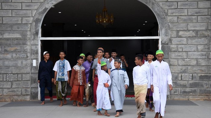 SYIAR ISLAM DARI NUU WAAR Dua santriwati berjalan menuju masjid di Pondok Pesantren Nuu Waar.
