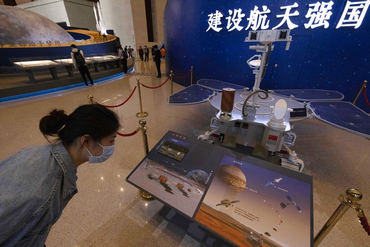 Chinese Mars Rover Landing A visitor to an exhibition on Chinas space program looks at a life size model of the Chinese Mars rover Zhurong, named after the Chinese god of fire, at the National Museum in Beijing on Thursday, May 6, 2021. China has landed a spacecraft on Mars for the first time in the latest advance for its space program. The official Xinhua News Agency said Saturday, May 15, that the lander had touched down, citing the China National Space Administration. Chinese characters read: Build a Space Power. (AP Photo/Ng Han Guan)