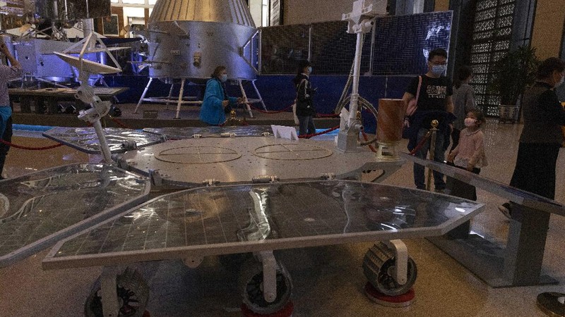 A visitor to an exhibition on China's space program looks at a life size model of the Chinese Mars rover Zhurong, named after the Chinese god of fire, at the National Museum in Beijing on Thursday, May 6, 2021. China has landed a spacecraft on Mars for the first time in the latest advance for its space program. The official Xinhua News Agency said Saturday, May 15, that the lander had touched down, citing the China National Space Administration. Chinese characters read: Build a Space Power. (AP Photo/Ng Han Guan)