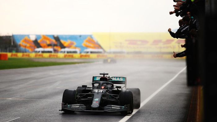 ISTANBUL, TURKEY - NOVEMBER 15: Race winner Lewis Hamilton of Great Britain driving the (44) Mercedes AMG Petronas F1 Team Mercedes W11 crosses the line and wins a 7th F1 World Drivers Championship as his team celebrate on the pitwall during the F1 Grand Prix of Turkey at Intercity Istanbul Park on November 15, 2020 in Istanbul, Turkey. (Photo by Bryn Lennon/Getty Images)