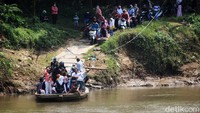 Warga menyeberangi sungai menggunakan perahu eretan untuk menghindari kemacetan di jalan yang menuju kawasan wisata pantai Tanjung Pasir.
