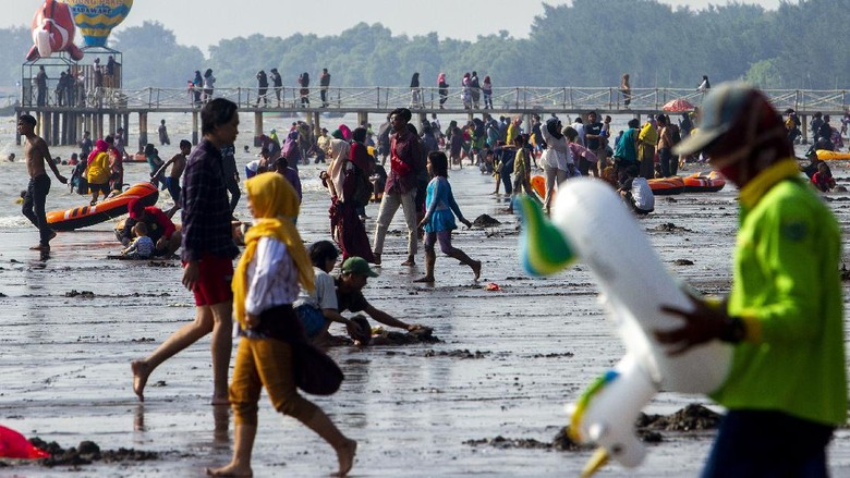 PANTAI TANJUNG PAKIS KARAWANG Wisatawan berswafoto sambil menikmati matahari terbit di Pantai Tanjung Pakis, Desa Pakis Jaya, Karawang, Jawa Barat, Sabtu (15/5/2021). Menteri Pariwisata dan Ekonomi Kreatif Sandiaga Uno mengingatkan kepada pengelola tempat wisata di berbagai daerah untuk tetap menjalankan protokol kesehatan ketat agar angka kasus COVID-19 tidak mengalami peningkatan setelah libur Lebaran. ANTARA FOTO/M Ibnu Chazar/wsj.