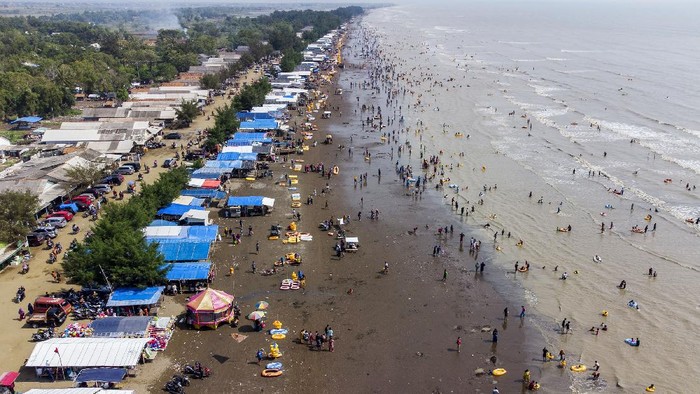 Wisatawan berswafoto sambil menikmati matahari terbit di Pantai Tanjung Pakis, Desa Pakis Jaya, Karawang, Jawa Barat, Sabtu (15/5/2021). Menteri Pariwisata dan Ekonomi Kreatif Sandiaga Uno mengingatkan kepada pengelola tempat wisata di berbagai daerah untuk tetap menjalankan protokol kesehatan ketat agar angka kasus COVID-19 tidak mengalami peningkatan setelah libur Lebaran. ANTARA FOTO/M Ibnu Chazar/wsj.