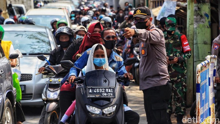 Petugas Polri dibantu TNI dan pemerintah Kabupaten menjaga akses jalan menuju tempat wisata pantai Tanjung Pasir, Kabupaten Tangerang, Banten, Sabtu (15/5/2021). Upaya tersebut untuk menghindari kerumunan warga di masa pandemi. Akibat penutupan jalan, arus lalu-lintas terpantau padat merayap. Cuaca terpantau cerah.