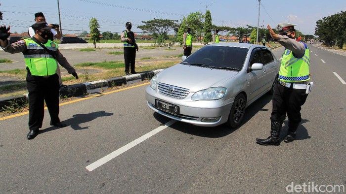 Petugas Kepolisian Polresta Cirebon memeriksa kelengkapan surat milik pengendara yang melintas di jalur Pantura Susukan, Kabupaten, Cirebon, Jawa Barat, Sabtu (15/5/2021). Pemeriksaan kelengkapan dokumen tersebut untuk memastikan kendaraan dengan plat nomor di luar Cirebon yang akan menuju Jakarta sudah dilengkapi dengan surat keterangan bebas COVID-19. ANTARA FOTO/Dedhez Anggara/wsj.