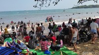 Pengunjung yang berdatangan tumpah ruah bermain di area pantai. 