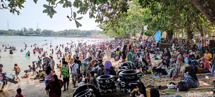 Hari ini kawasan Pantai Carita, Pandeglang, Banten, dipadati oleh pengunjung. Pengunjung tumpah ruah bermain di area pantai.