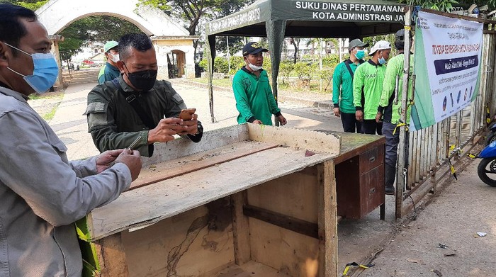 Sejumlah aparat keamanan berjaga di pintu masuk TPU Tegal Alur usai sejumlah peziarah menjebol pagar.