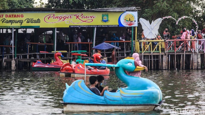 Wisata Air Situ Cipondoh Ramai Warga menikmati suasana wisata air di Situ Cipondoh pada musim libur lebaran Idul Fitri 1442 H, di Kota Tangerang, Banten, Sabtu (15/5/2021). Sejumlah pengunjung terlihat mengabaikan protokol kesehatan seperti melepas masker saat bermain atau menunggu wahana perahu wisata.