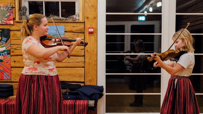 Guru musik di Pulau Kihnu Maria Michelson mengajarkan bermain biola kepada muridnya. (Photo by Alessandro RAMPAZZO / AFP)