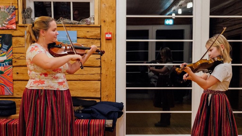 Pulau Kihnu di Estonia Guru musik di Pulau Kihnu Maria Michelson mengajarkan bermain biola kepada muridnya. (Photo by Alessandro RAMPAZZO / AFP)