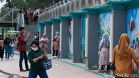 Pengunjung membawa serta keluarganya berwisata di Taman Kota 2 BSD. Area mural menjadi spot foto favorit.