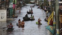 Warga mengarungi jalan-jalan yang banjir dengan perahu di Anama, negara bagian Amazonas, Brasil, Minggu (16/5/2021) waktu setempat.  