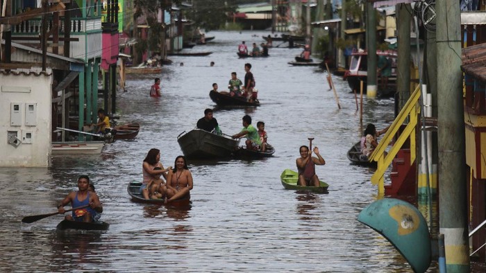 Residents navigate flooded streets in Anama, Amazonas state, Brazil (AP Photo/Edmar Barros)