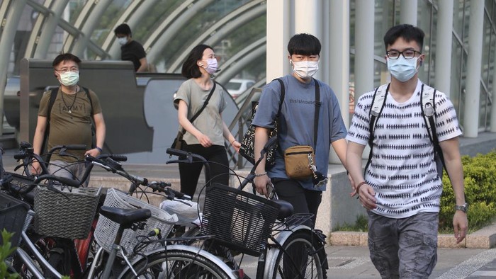 People wear face masks to protect against the spread of the coronavirus after the COVID-19 alert raise to level 3 in Taipei, Taiwan, Saturday, May 15, 2021. Taiwan, which has had enviable success in containing COVID-19, imposed new restrictions in its capital city on Saturday as it battled its worst outbreak since the pandemic began. (AP Photo/Chiang Ying-ying)