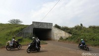 Pengendara motor saat melintas di area proyek  tol Cimanggis-Cibitung di Desa Burangkeng Kecamatan Setu Kabupaten Bekasi, Jawa Barat, Senin (17/05/2021), yang terhenti pembangunannya.