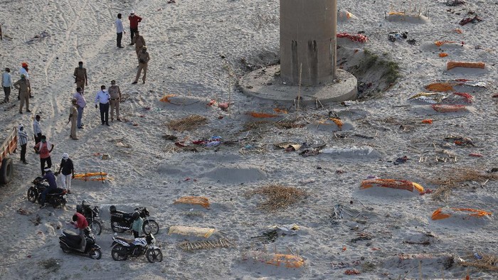Bodies of suspected Covid-19 victims are seen in shallow graves buried in the sand near a cremation ground on the banks of Ganges River in Prayagraj, India, Saturday, May 15, 2021. (AP Photo/Rajesh Kumar Singh)