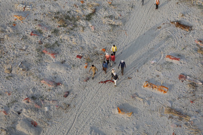 Bodies of suspected Covid-19 victims are seen in shallow graves buried in the sand near a cremation ground on the banks of Ganges River in Prayagraj, India, Saturday, May 15, 2021. (AP Photo/Rajesh Kumar Singh)