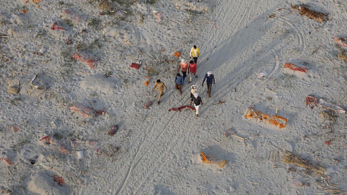 Bodies of suspected Covid-19 victims are seen in shallow graves buried in the sand near a cremation ground on the banks of Ganges River in Prayagraj, India, Saturday, May 15, 2021. (AP Photo/Rajesh Kumar Singh)