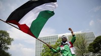 Massa terus mengibarkan bendera Palestina sepanjang aksi.