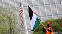Mereka berorasi sambil mengibarkan bendera Palestina.