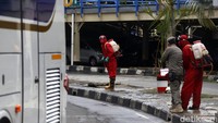 Satu per satu bus yang memasuki terminal disemprot disinfektan.