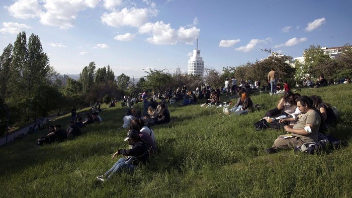 People enjoy the good weather at a park, hours after a 17-day full lockdown ended, in Ankara, Turkey, Monday, May 17, 2021. Turkey's daily COVID-19 infections have dropped to levels last seen in mid-March as the country ended its strictest restrictions.(AP Photo/Burhan Ozbilici)