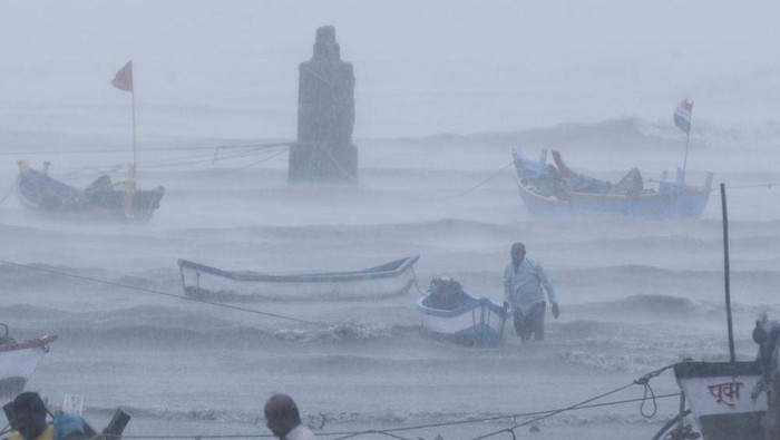 A fisherman waits for help as he tries to move a fishing boat to a safer ground on the Arabian Sea coast in Mumbai, India, Monday, May 17, 2021. Cyclone Tauktae, roaring in the Arabian Sea was moving toward Indias western coast on Monday as authorities tried to evacuate hundreds of thousands of people and suspended COVID-19 vaccinations in one state. (AP Photo/Rafiq Maqbool)