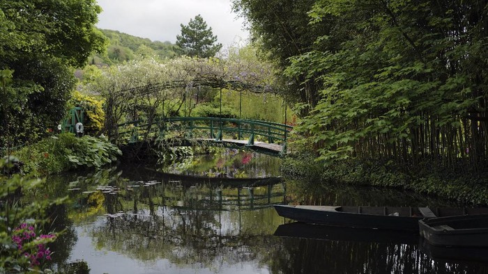 The green bench in the Japanese-inspired water garden of Claude Monet's house, French impressionist painter who lived from 1883 to 1926, waits ahead of the re-opening, in Giverny, west of Paris, Monday May 17, 2021. Lucky visitors who'll be allowed back into Claude Monet's house and gardens for the first time in over six months from Wednesday will be treated to a riot of color, with tulips, peonies, forget-me-nots and an array of other flowers all competing for attention. (AP Photo/Francois Mori)