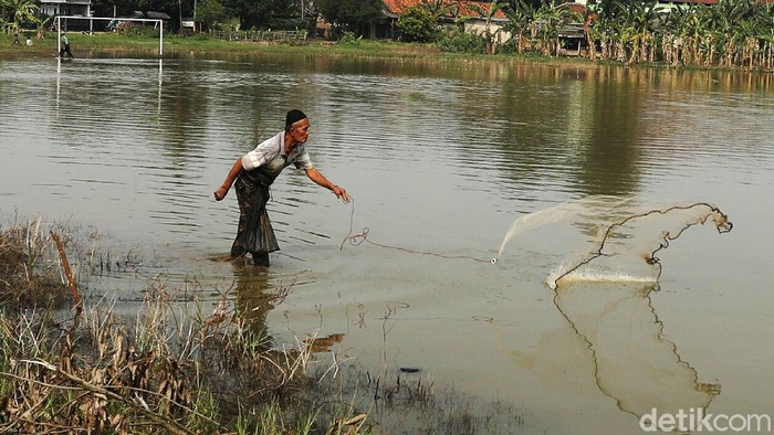 Potret Warga Mancing Ikan di Lapangan Sepakbola yang Terendam Banjir Lapangan sepak bola, di Rawa Tengah, Cikiwul, Kota Bekasi, yang terendam banjir dimanfaatkan sejumlah warga untuk memancing ikan.